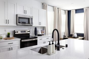 A modern kitchen with white cabinets and a large island.